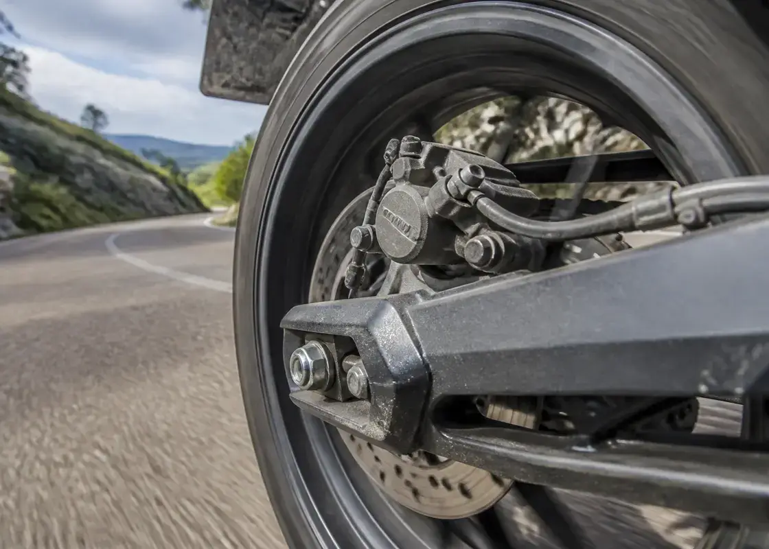 Vue rapprochée du freinage arrière d'une moto en action sur route sinueuse