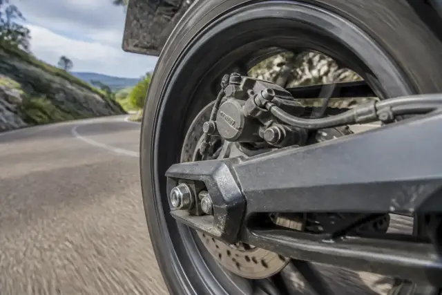 Vue rapprochée du freinage arrière d'une moto en action sur route sinueuse